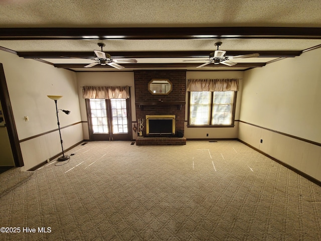 unfurnished living room featuring a brick fireplace, beamed ceiling, and a textured ceiling