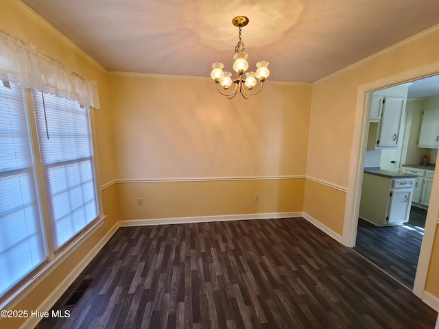 spare room with a healthy amount of sunlight, dark hardwood / wood-style floors, a chandelier, and ornamental molding