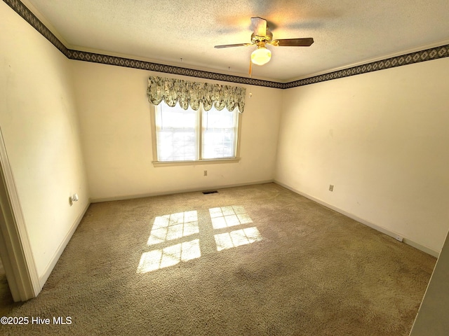 carpeted empty room with ceiling fan and a textured ceiling