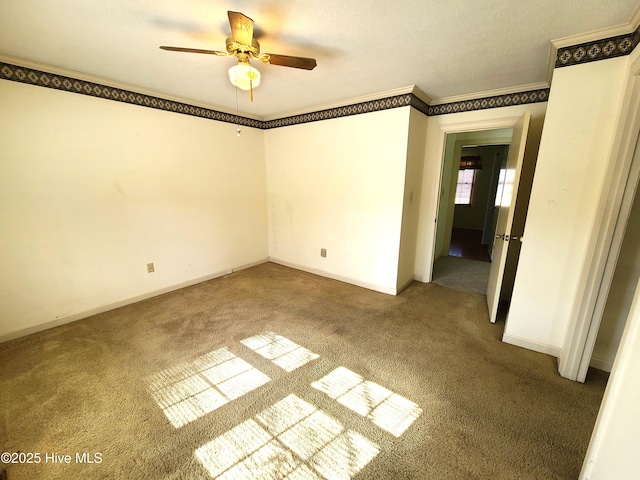 carpeted spare room with crown molding and ceiling fan