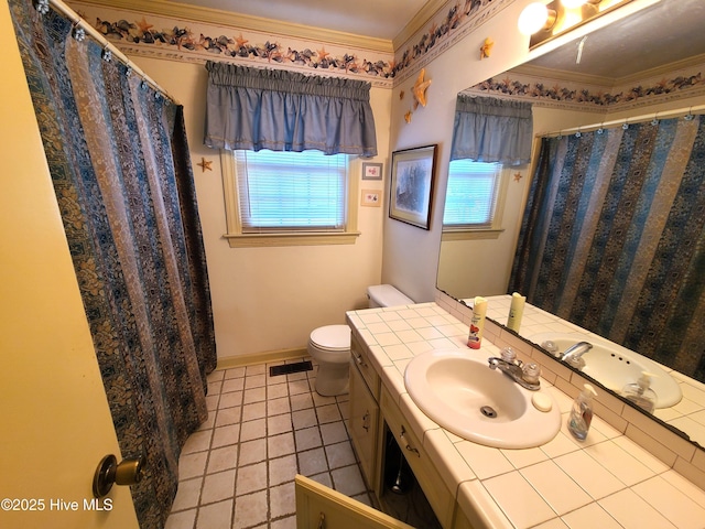 bathroom featuring vanity, tile patterned flooring, crown molding, and toilet