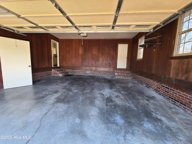 garage with a garage door opener and wooden walls