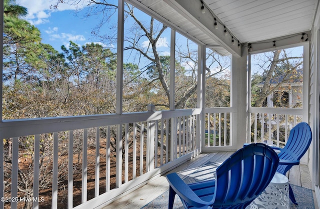 unfurnished sunroom with rail lighting