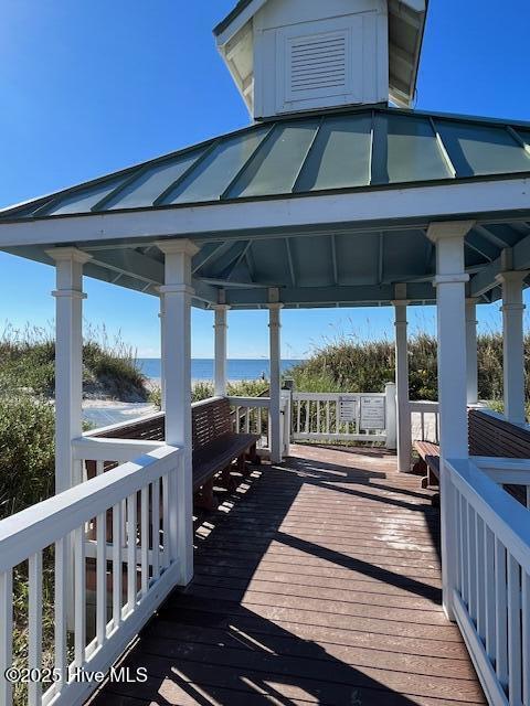 wooden terrace featuring a gazebo and a water view