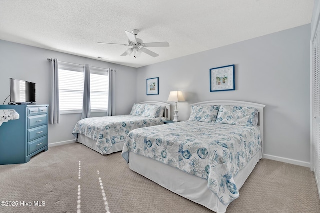 carpeted bedroom featuring ceiling fan and a textured ceiling