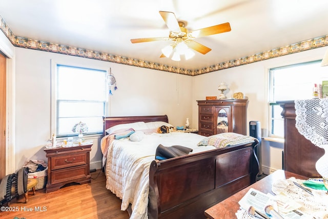 bedroom with light hardwood / wood-style floors and ceiling fan