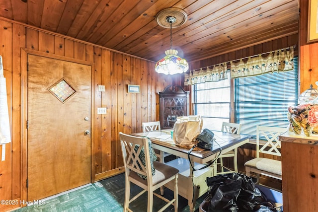 dining room with dark parquet floors, wood ceiling, and wooden walls