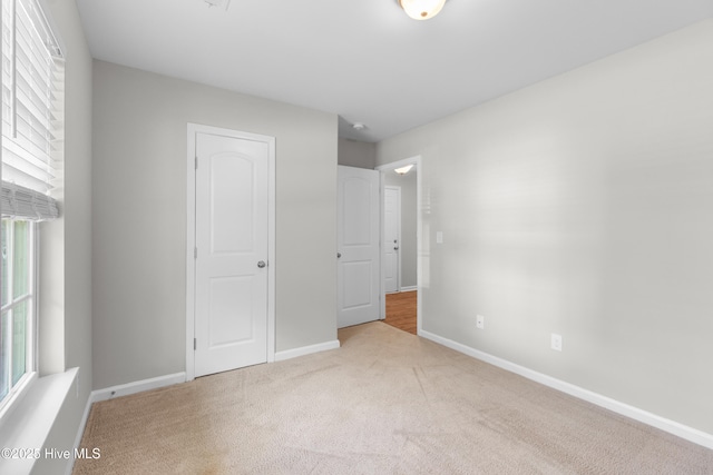 unfurnished bedroom featuring baseboards and carpet
