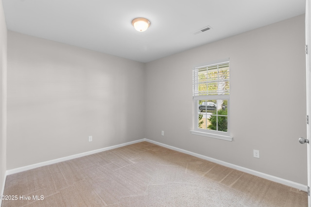 carpeted spare room with baseboards and visible vents