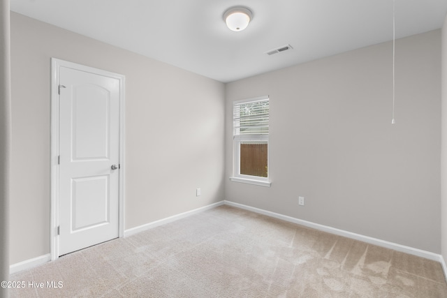 carpeted spare room with baseboards and visible vents