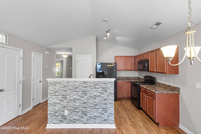 kitchen with dark countertops, visible vents, brown cabinets, lofted ceiling, and black appliances