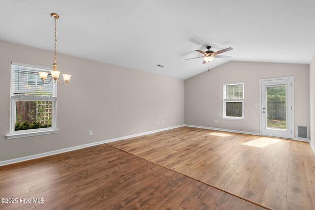 unfurnished living room featuring wood finished floors, ceiling fan with notable chandelier, baseboards, and lofted ceiling