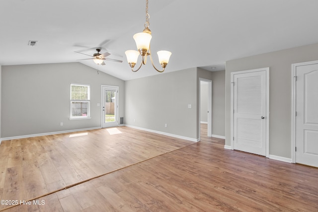 spare room with baseboards, visible vents, lofted ceiling, ceiling fan with notable chandelier, and wood finished floors