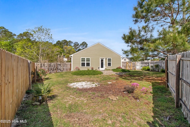 back of property with a fenced backyard and a lawn