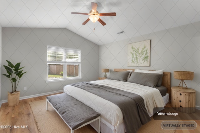 bedroom featuring lofted ceiling, wood finished floors, visible vents, baseboards, and ceiling fan