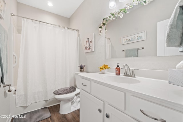 full bathroom with vanity, hardwood / wood-style floors, shower / bath combo, and toilet