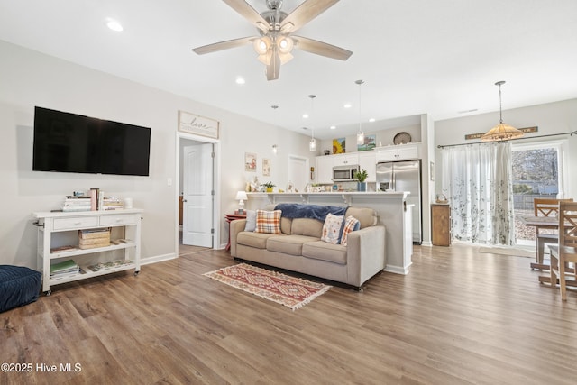 living room featuring ceiling fan and light wood-type flooring