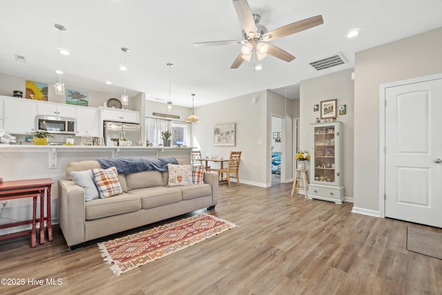 living room featuring ceiling fan and light wood-type flooring