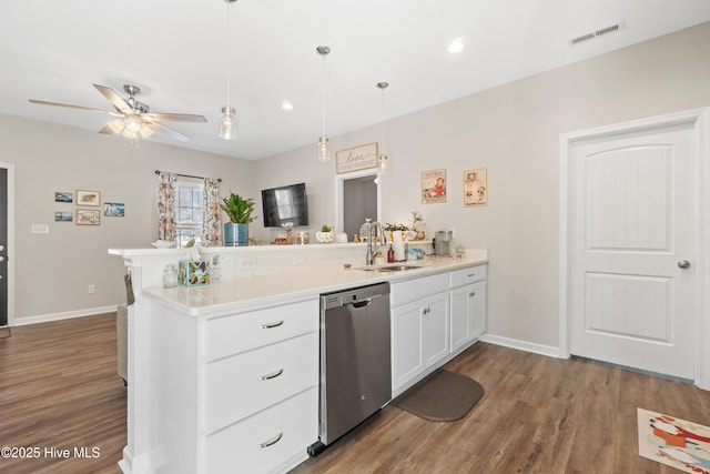 kitchen featuring sink, white cabinetry, decorative light fixtures, stainless steel dishwasher, and hardwood / wood-style floors