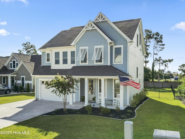 view of front of property featuring a garage, covered porch, and a front yard