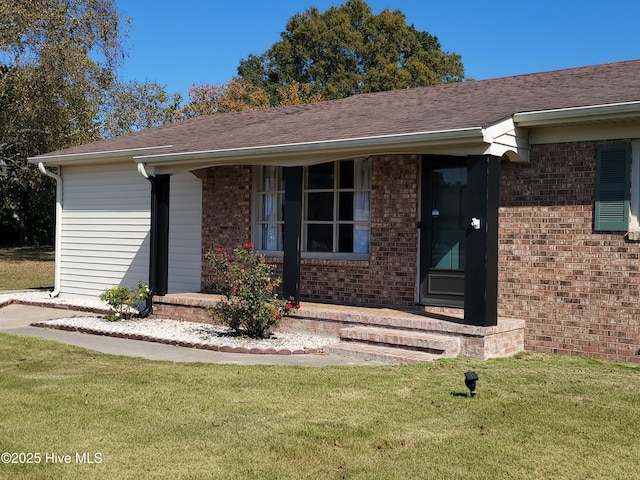 view of exterior entry featuring a lawn