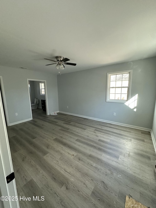 spare room featuring ceiling fan, a healthy amount of sunlight, and wood-type flooring