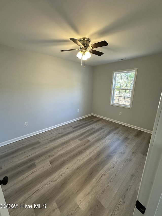 spare room with hardwood / wood-style floors and ceiling fan