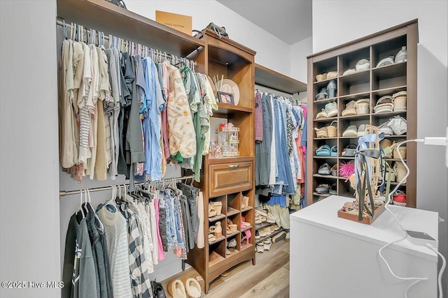 walk in closet with light hardwood / wood-style floors