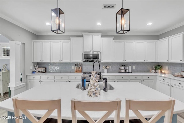 kitchen with an island with sink, a breakfast bar area, and decorative light fixtures