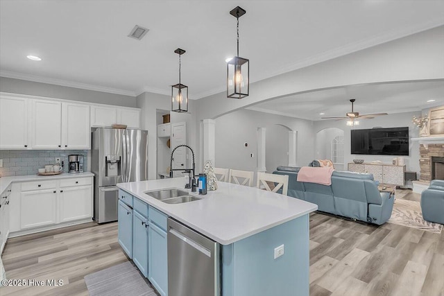 kitchen featuring stainless steel appliances, sink, a center island with sink, and white cabinets