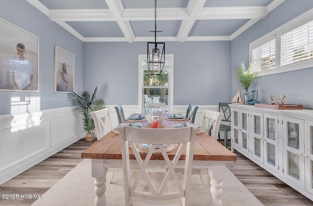 dining room featuring an inviting chandelier, hardwood / wood-style floors, coffered ceiling, and beamed ceiling