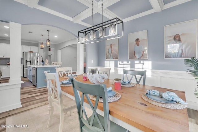 dining space featuring beamed ceiling, decorative columns, sink, ornamental molding, and coffered ceiling