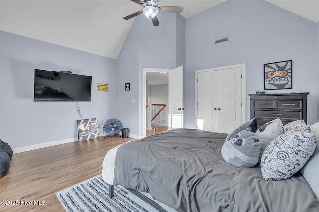 bedroom with ceiling fan, wood-type flooring, and high vaulted ceiling