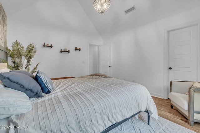 bedroom with high vaulted ceiling and light hardwood / wood-style floors