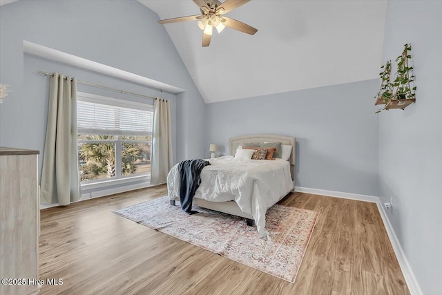 bedroom with high vaulted ceiling, ceiling fan, and light hardwood / wood-style flooring