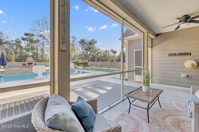 sunroom / solarium featuring ceiling fan