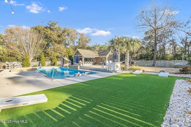 view of pool with a yard, a patio, and a water slide