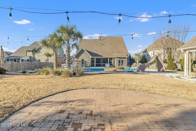 back of house with a pool and a patio area