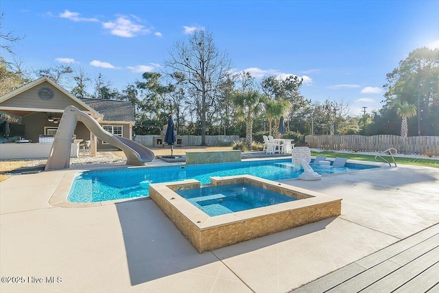 view of swimming pool featuring an in ground hot tub, a water slide, and a patio