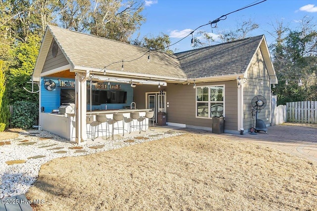 rear view of property with an outdoor bar