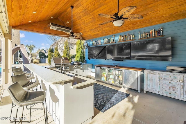 view of patio featuring exterior kitchen and an outdoor bar