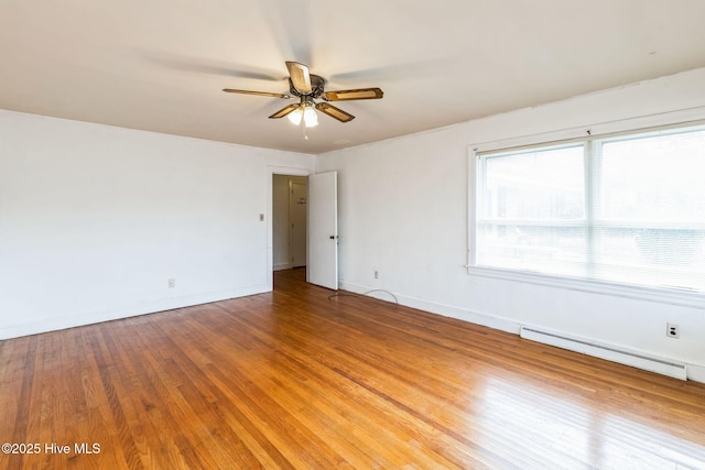 empty room with a baseboard heating unit, wood-type flooring, and ceiling fan