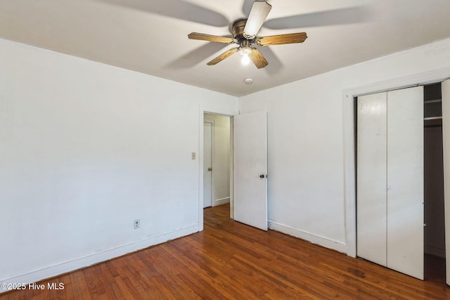 unfurnished bedroom with ceiling fan, dark hardwood / wood-style floors, and a closet