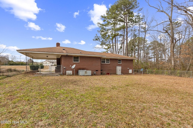 back of house with a carport and a lawn