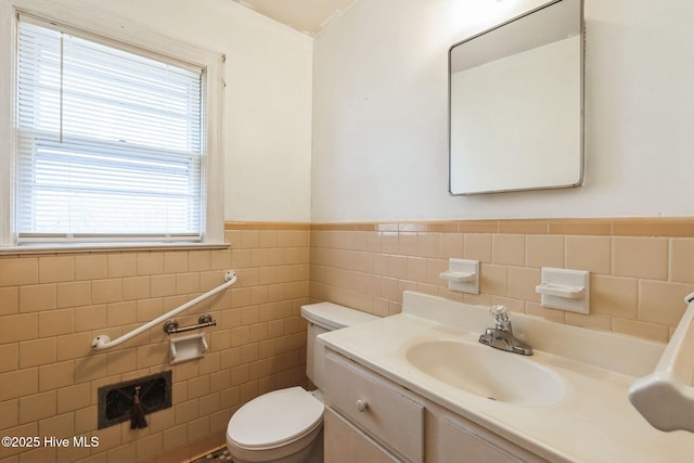 bathroom with vanity, tile walls, and toilet