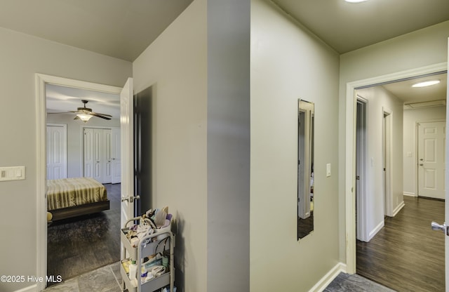 hallway with baseboards and wood finished floors