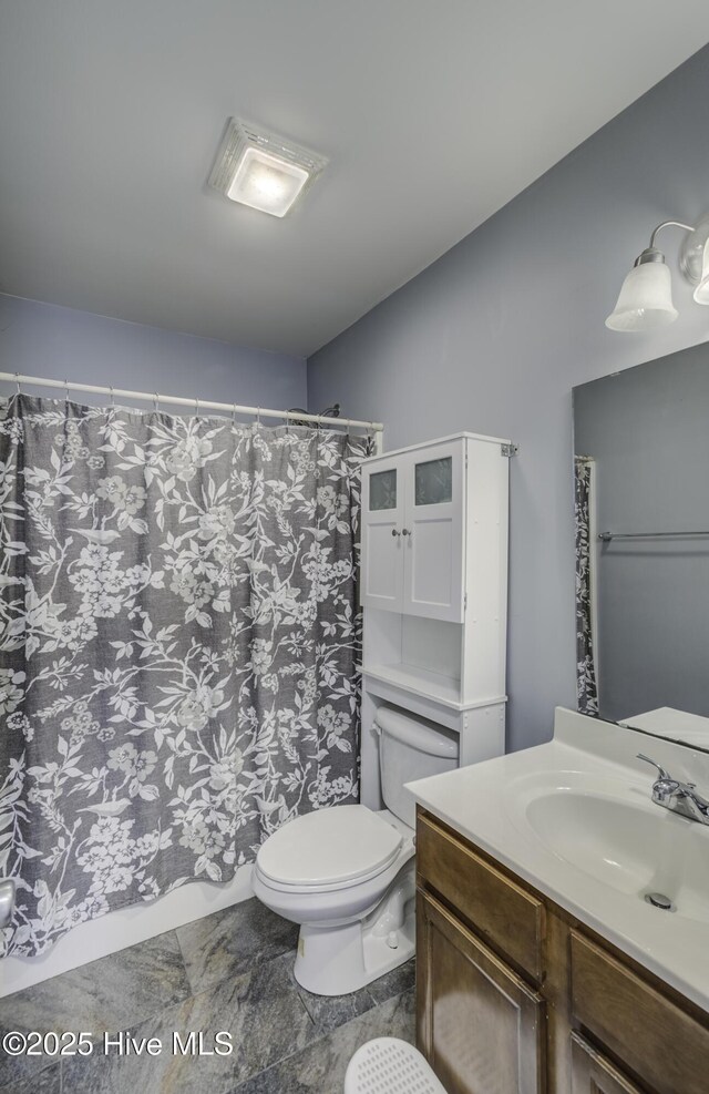 bathroom featuring vanity, toilet, and a shower with shower curtain