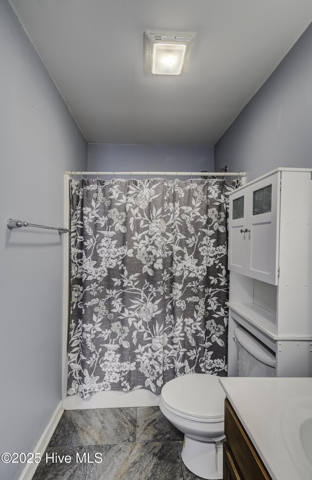 bathroom featuring a shower with curtain, vanity, and toilet