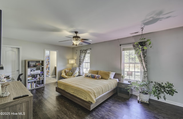 bedroom with dark wood-type flooring, visible vents, ceiling fan, and baseboards