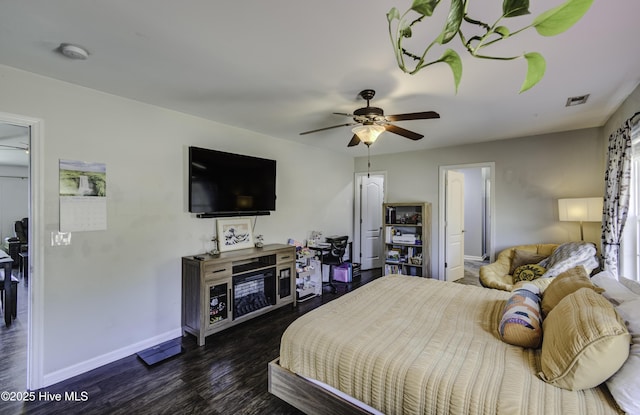 bedroom featuring a ceiling fan, dark wood-style flooring, visible vents, and baseboards